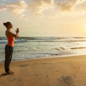 Woman doing yoga on beach